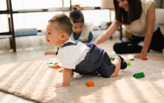 Toddler crawling during a playful occupational therapy session in Phnom Penh, supporting gross motor development and sensory integration.