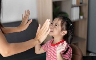A smiling child practicing social interaction and engagement during an occupational therapy session at OrbRom Center in Phnom Penh.