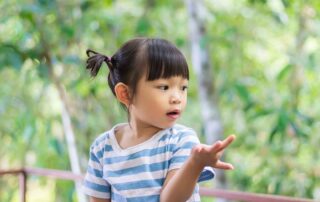 Young child developing hand coordination and fine motor skills through play during occupational therapy session at OrbRom Center Phnom Penh