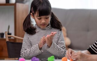 A child with ADHD engaged in a sensory-focused occupational therapy activity with colorful play dough to improve attention and regulation skills.