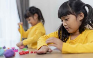 Children strengthening fine motor skills and social interaction through group play activities during occupational therapy at OrbRom Center Phnom Penh