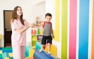 Occupational therapist helping a child develop balance and coordination skills during therapy at OrbRom Center Phnom Penh