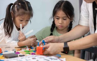 Children participating in a hands-on STEM activity to support fine motor skills and focus during occupational therapy in Phnom Penh