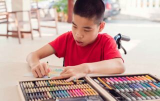 Child practicing fine motor skills through drawing activities during occupational therapy session at OrbRom Center Phnom Penh