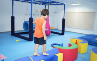 Child practicing balance and motor skills during occupational therapy at OrbRom Center in Phnom Penh’s sensory gym.