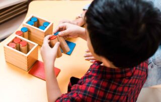A child engages in a cognitive and fine motor task using sensory blocks during occupational therapy in Phnom Penh.