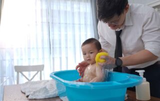 A caregiver supporting a child during bath time, using gentle sensory input to build comfort, regulation, and sensory processing at OrbRom Center in Phnom Penh.