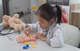 Therapist supporting a child with play-based learning tools in a Phnom Penh school focused on developing young minds