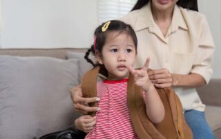 Young child preparing for school with help from therapist during occupational therapy session in Phnom Penh